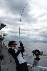 Woman reeling in a fish
