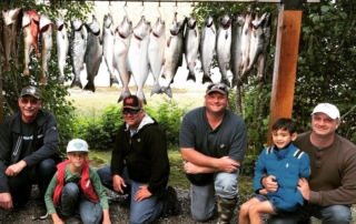 A family of anglers pose for their Alaska family vacation at Favorite Bay Lodge.