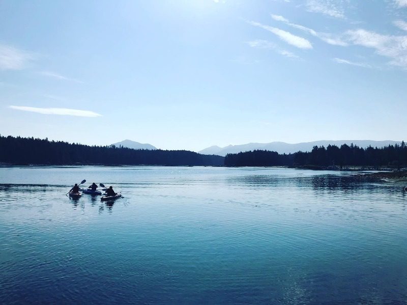 2024 Alaska Vacation Packages: A beautiful view of kayakers exploring an inlet in Southeast Alaska.